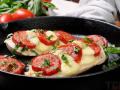 Курячі відбивні, запечені з яйцем сиром та помідорами: рецепт ефектної страви