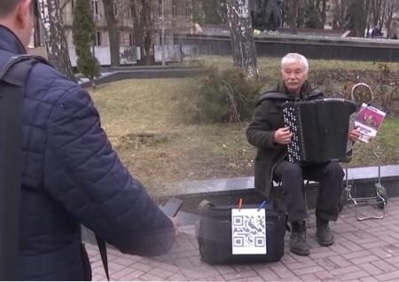 Щоб не обікрали: вуличний музикант-пенсіонер приймає електронні гроші