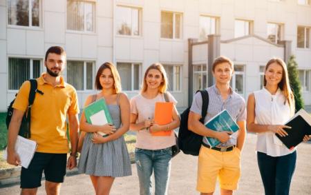 portrait_of_group_of_happy_students_in_casual_outfit_with_books_while_sta_29.03.23