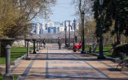 _vesna_trotuar_parkom_zhinka_v_chervonomu_palto_sonyachno_vid_na_z_22.04.26